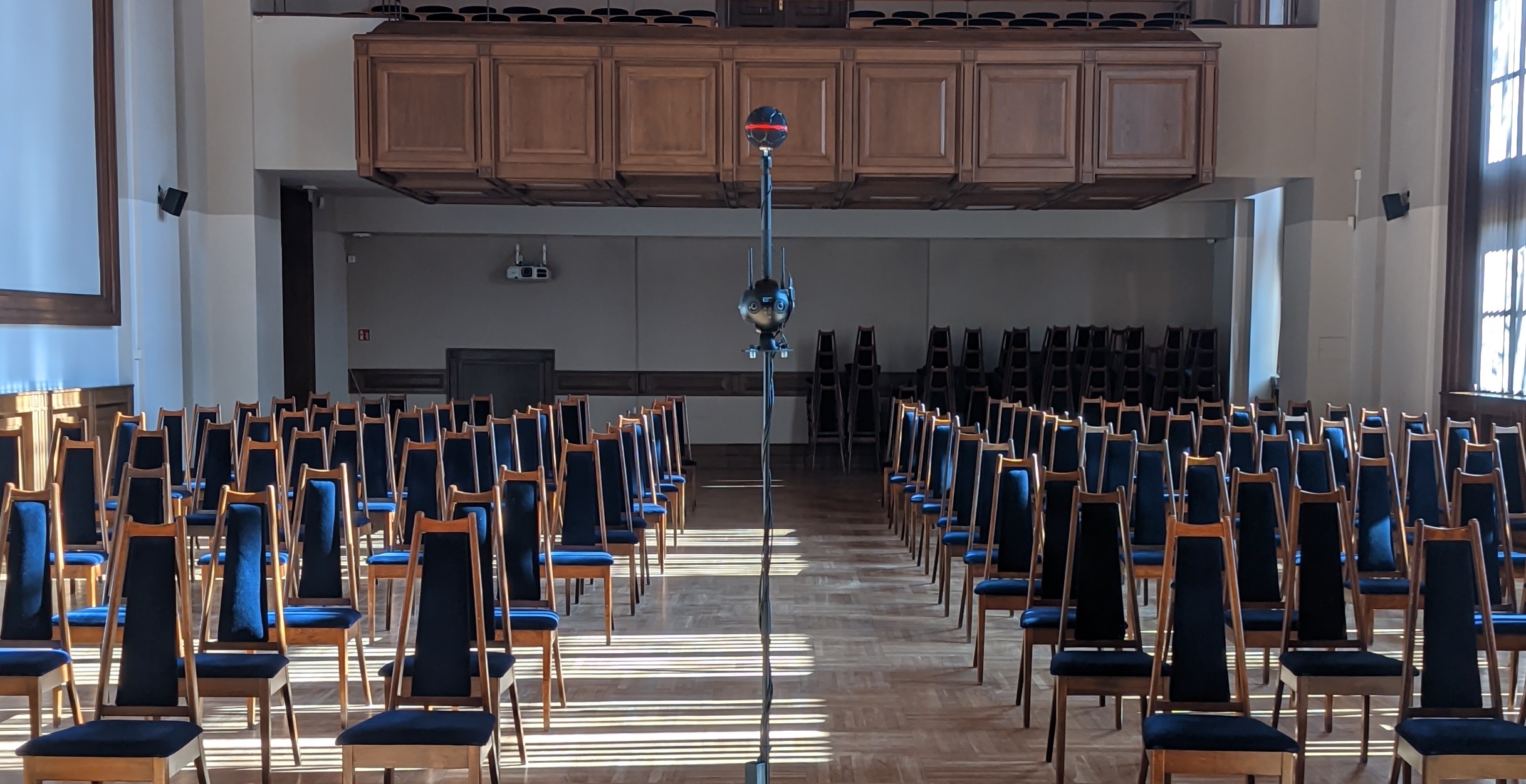 The capture rig -- Zylia ZM-1 and Insta360 Pro 2 on a boom stand -- centred in the empty concert hall before the WETI 70th-anniversary concert